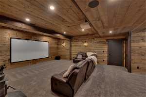 Carpeted cinema room with wooden walls and wooden ceiling