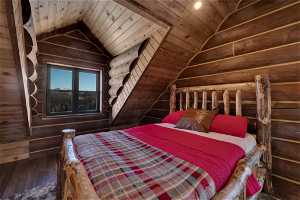 Unfurnished bedroom featuring vaulted ceiling, dark hardwood / wood-style flooring, and wooden ceiling