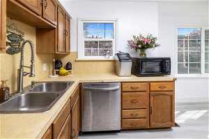 Kitchen with sink, dishwasher, and light hardwood / wood-style floors
