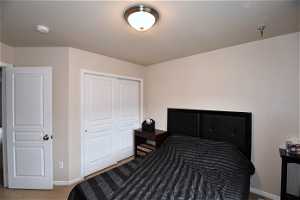 Bedroom with a closet and dark carpet