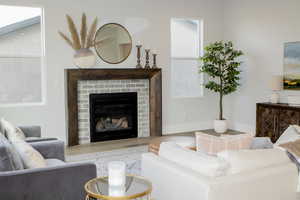 Living room with a fireplace and hardwood / wood-style flooring