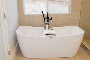 Bathroom with a bath and tile flooring