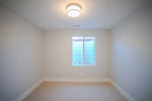 Spare room featuring a textured ceiling and carpet flooring