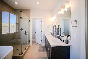 Bathroom featuring tile patterned flooring, vanity, and separate shower and tub