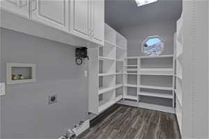 Interior space with dark LVP flooring, washer hookup, electric dryer hookup, cabinets, and gas dryer hookup