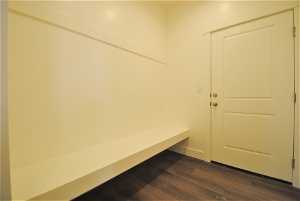 Mudroom with dark flooring and a large bench.