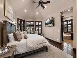 Bedroom with dark wood-type flooring, multiple windows, ensuite bathroom, and ceiling fan