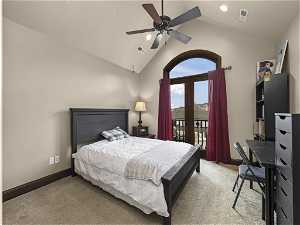 Carpeted bedroom featuring vaulted ceiling, access to exterior, and ceiling fan