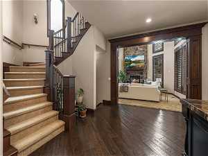 Foyer entrance with dark hardwood / wood-style flooring and a fireplace