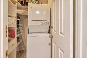 In Unit Laundry  area with hardwood / wood-style floors and stacked washer and dryer