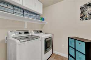 Laundry Room with light tile floors, wall cabinets and storage shelf.