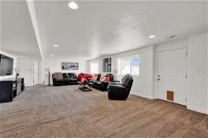 Spacious living room featuring full natural light windows, walk-in entry, recessed lighting, clean carpet.