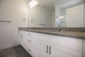 Bathroom with vanity with extensive cabinet space, tile floors, and double sink