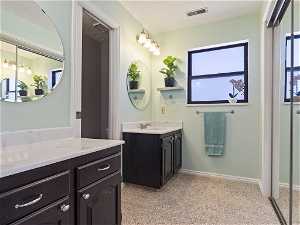 Bathroom with double vanity and a textured ceiling