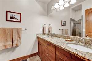 Master Bathroom with a shower with shower door and dual bowl vanity