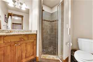 Master Bathroom with tile floors, toilet, walk in shower, and oversized vanity
