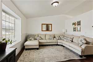 Living room featuring dark hardwood / wood-style flooring and vaulted ceiling