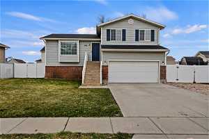Split level home with a garage and a front lawn