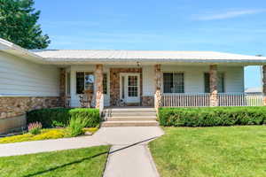 View of front of home featuring a front yard and covered porch