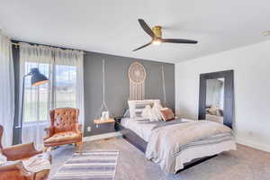 Carpeted bedroom featuring ceiling fan