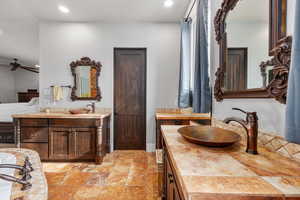 Bathroom featuring double vanity, tile floors, and ceiling fan