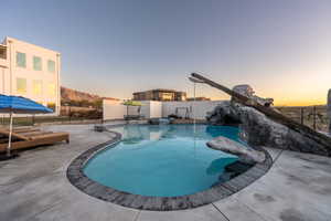 Pool at dusk with a patio area