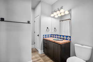 Bathroom featuring hardwood / wood-style flooring, toilet, and vanity