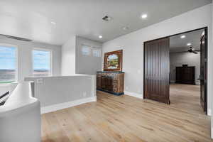 Interior space featuring light hardwood / wood-style flooring, a barn door, and ceiling fan