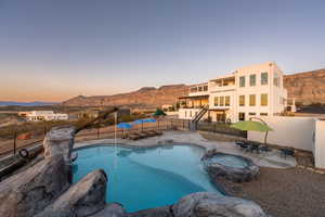 Pool at dusk with a patio area and a mountain view