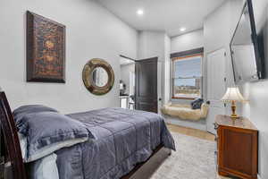 Bedroom featuring a high ceiling and light hardwood / wood-style floors