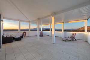 Patio terrace at dusk featuring an outdoor living space and a mountain view