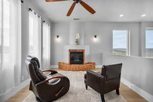 Sitting room with light hardwood / wood-style floors and ceiling fan