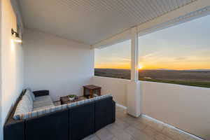 Patio terrace at dusk featuring a balcony