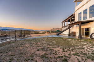 Yard at dusk featuring central AC unit, a patio area, and a mountain view