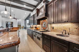 Kitchen with beamed ceiling, ceiling fan, light hardwood / wood-style floors, sink, and decorative light fixtures