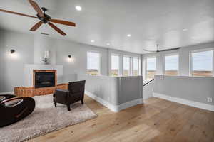 Living room with ceiling fan and light hardwood / wood-style floors