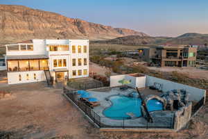 Pool at dusk featuring a mountain view, french doors, and a patio