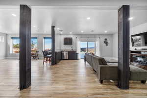 Living room featuring a fireplace, light wood-type flooring, and sink