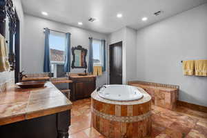 Bathroom featuring vanity, tile flooring, and a relaxing tiled bath