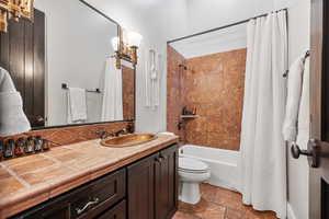 Full bathroom featuring vanity, toilet, shower / bath combo, and tile floors