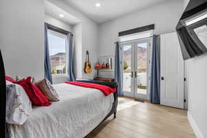 Bedroom featuring light hardwood / wood-style flooring, french doors, and access to exterior