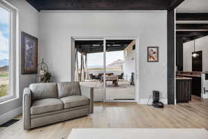 Living room featuring a mountain view, light hardwood / wood-style flooring, and beam ceiling