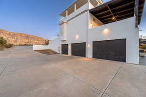 Property exterior at dusk with a garage and a mountain view