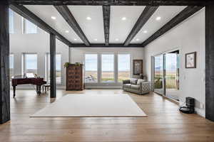 Living room with light hardwood / wood-style flooring and beam ceiling