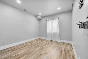 Empty room with light hardwood / wood-style flooring