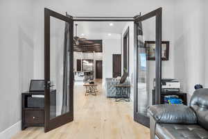 Corridor with french doors and light hardwood / wood-style flooring