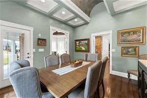 Dining area with coffered ceiling, ornamental molding, beam ceiling, and dark hardwood / wood-style floors