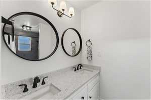 Bathroom featuring dual bowl vanity and ornamental molding