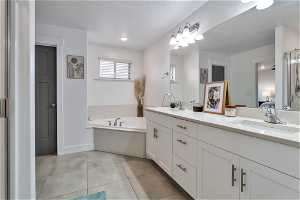 Bathroom with tile flooring, large, dual sink vanity, seperate water closet and a bathing tub