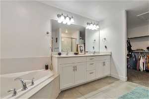 Master Bathroom with dual vanity, seperate shower, and bath, walk-in closet and tile floors